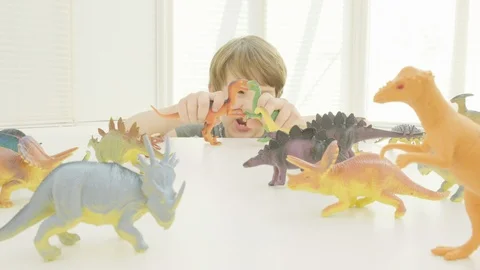 Boy playing with toy dinosaurs Video stock 129046700