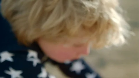 The boy is playing with a toy green dump truck on the beach Stock-Footage 76004965
