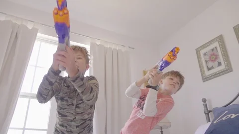 Boy playing toy nerf gun war combat indoors as action warriors Stock Footage 105544235