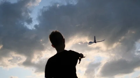 The boy is playing with a toy plane. Sunset. Slow motion. 스톡 동영상 121205440