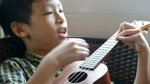 Boy playing ukulele at home Stock Footage 80901219