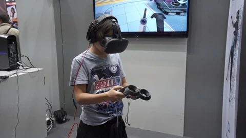 Boy playing video game with HTC Vive VR headset Stock Footage 74112966