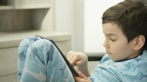 Boy Playing Video-Game online holding tablet device 4K R3D Stock Footage 129058334