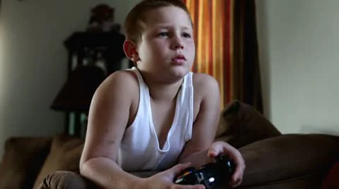 Boy playing video games on couch Stockbeeldmateriaal 8928536