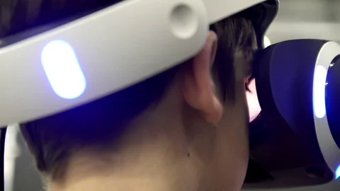 The boy is playing in a virtual helmet close up Stock Footage 83433049