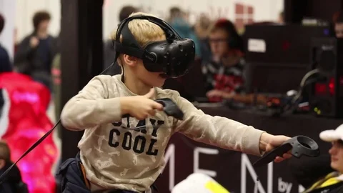 Boy playing virtual reality game in HTC Vive VR headset with accessories Stock Footage 81513689