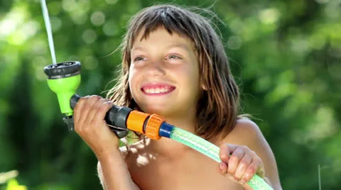 Boy playing with water in the garden Stock Footage 24916361