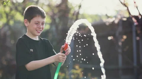 Boy playing with water from a hose. Stock Footage 62397309