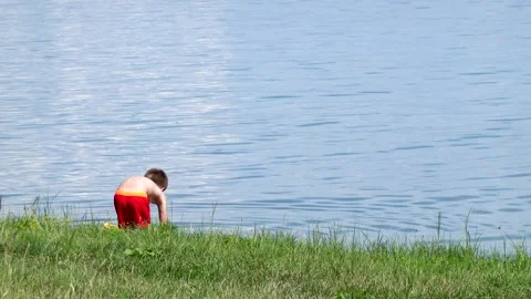 A boy is playing in the water in the summer during the holidays Stock Footage 245757074