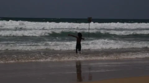 Boy playing with the waves Stock Footage 51329300