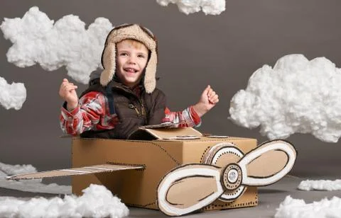 The boy plays in an airplane made of cardboard box and dreams of becoming a p Stock Photos
