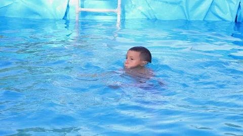 The boy plays and swims in the pool Stock Footage 315030577