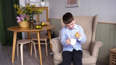 The boy plays with a artificial lemon and a mug Video stock 154127712
