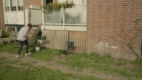 A boy plays with a ball in and around his house Stock Footage 308933353