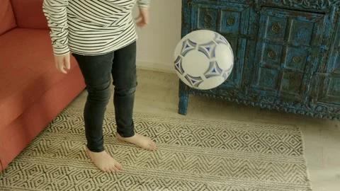A boy plays with a ball in and around his house Stock Footage 308933447