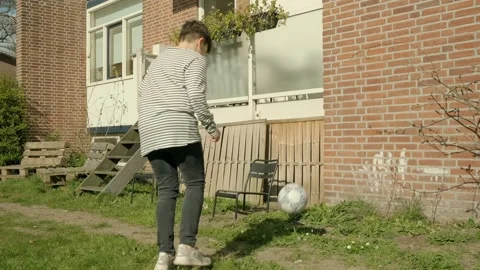 A boy plays with a ball in and around his house Stock Footage 308933500