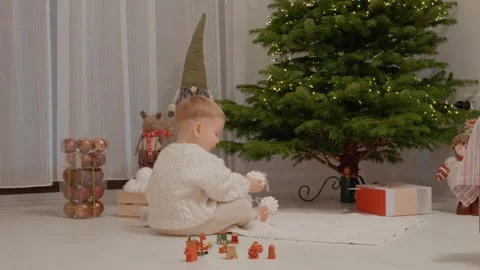 Boy plays with baubles while decorating the Christmas tree at home Stock Footage 346697398
