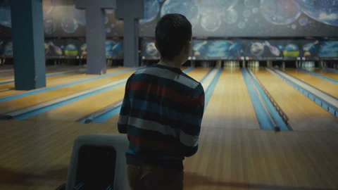 Boy plays bowling. He rolls the ball and knocks down skittles Stock Footage 89229319