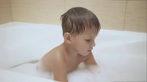 Boy plays with bubbles while taking a bath Stock Footage 77260934