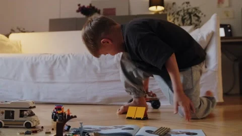 A boy plays with a car that he assembled from a construction set. Stock Footage 252382856