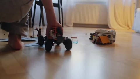A boy plays with a car that he assembled from a construction set. Stock Footage 252383428