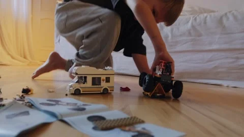 A boy plays with a car that he assembled from a construction set. Stock Footage 252383569