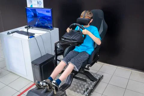 A boy plays on the car simulator Stock Photos