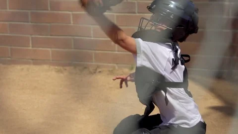 A boy plays catcher in a little league baseball game, super slow motion. Stock Footage