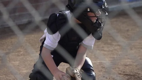 A boy plays catcher in a little league baseball game, super slow motion. Stock Footage
