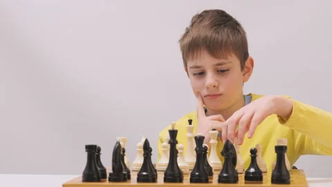 Boy plays chess and reflects on next move Video stock 172490611