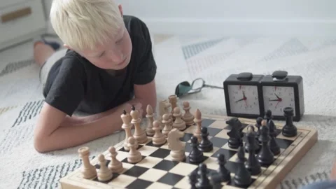 A boy plays chess at home with his dad Stock Footage 139610146