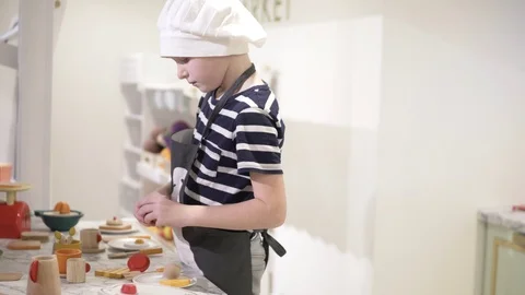 The boy plays in the children's kitchen Stock Footage 99470297