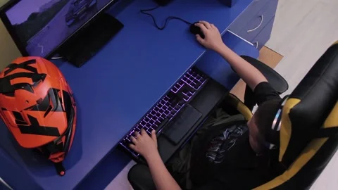 Boy plays computer games sitting at the gaming table Stock Footage 200256237