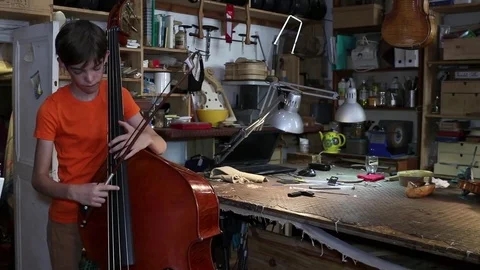 Boy plays the double bass Stock Footage 83434315