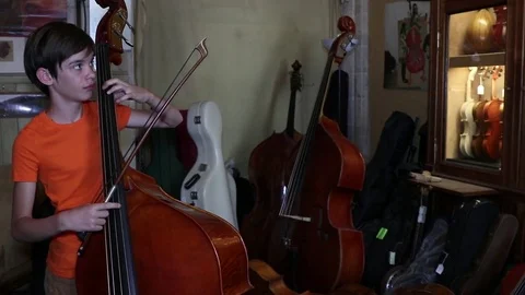 Boy plays the double bass Stock Footage 83434357