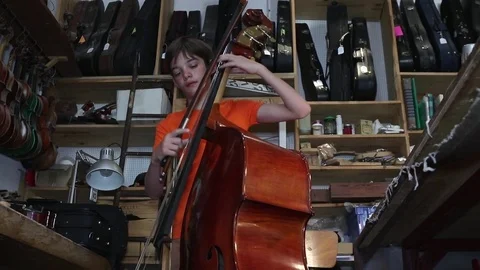 Boy plays the double bass Stock Footage 83434365