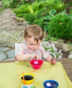 Boy Plays with a Easter Egg in Pink Dye Stock Photos