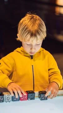 The boy plays with the electronic designer on the light table VERTICAL FORMAT Stock Photos
