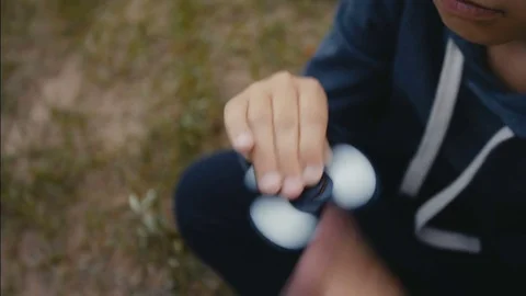 A boy plays with fidget spinner Stock Footage 76622939
