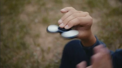 A boy plays with fidget spinner Stock Footage 76638328