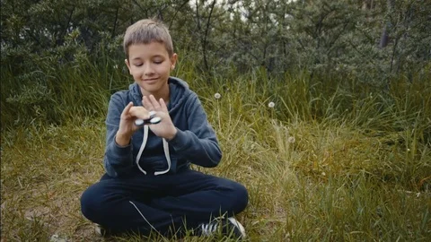 A boy plays with fidget spinner Video stock 76646250