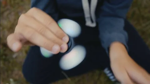 A boy plays with fidget spinner Stock Footage 76649885