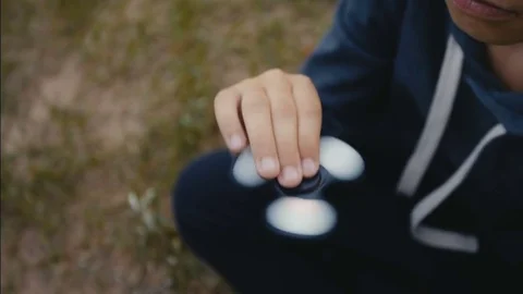 A boy plays with fidget spinner slow motion Stock Footage 76622232
