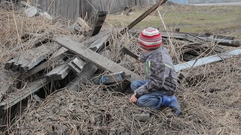 The boy plays for four years on the ruins of an old wooden house Stock Footage 74948044