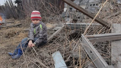 The boy plays for four years on the ruins of an old wooden house Stock Footage 74948558