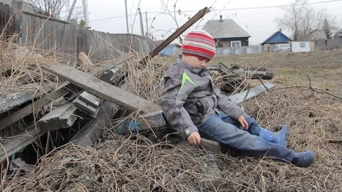 The boy plays for four years on the ruins of an old wooden house Stock Footage 74948732