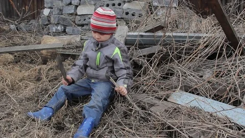 The boy plays for four years on the ruins of an old wooden house Stock Footage 74948744