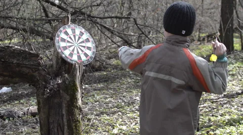 A Boy Plays a Game of Darts in the Forest Stock Footage 62526118