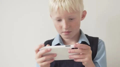 A boy plays a game on a mobile phone Stock Footage 139615205