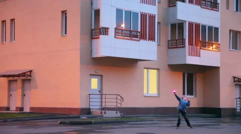 Boy plays with hand gear propeller near apartment house Stock Footage 992600